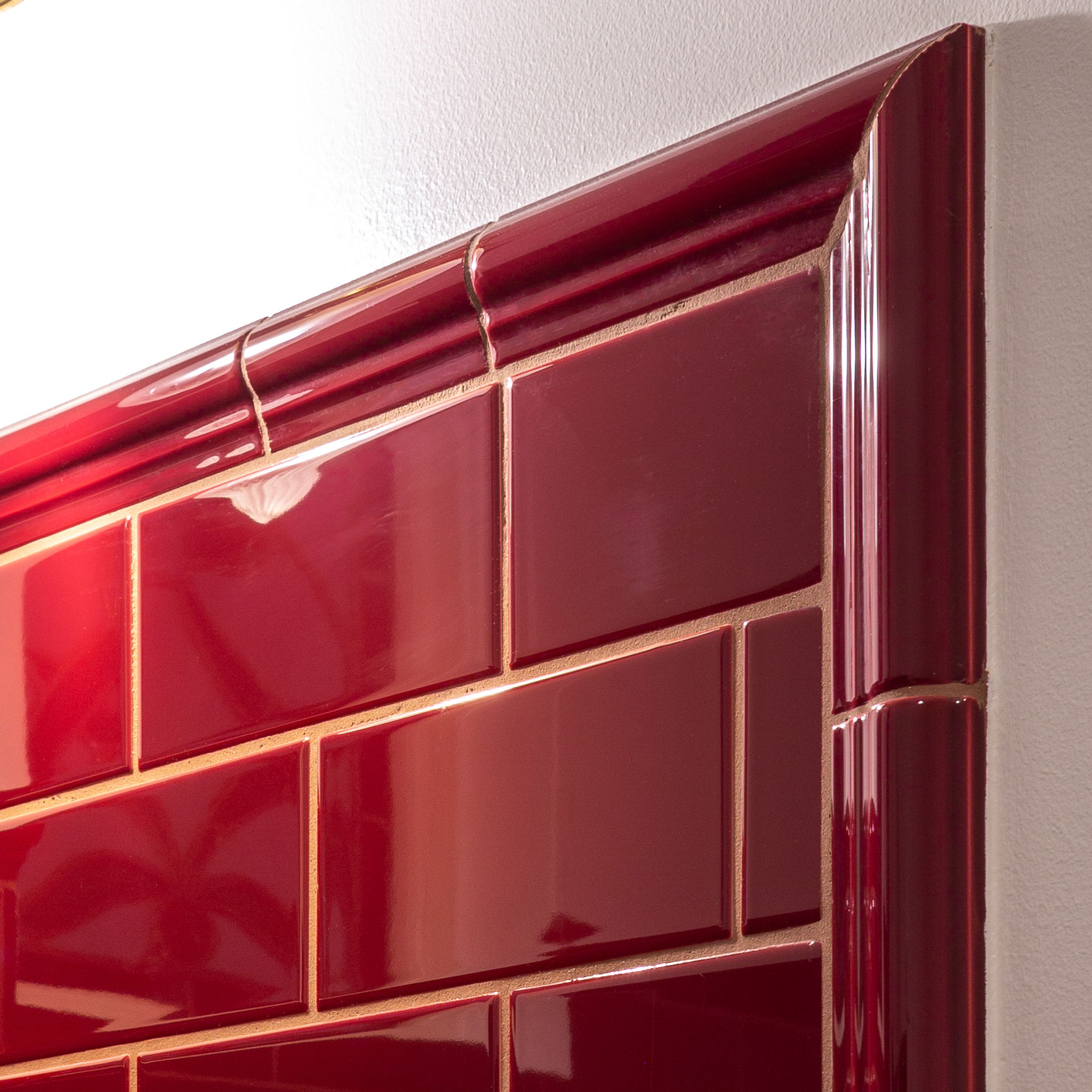 Flisebelagt hjørne i vinrød med dekorativ profileret kant