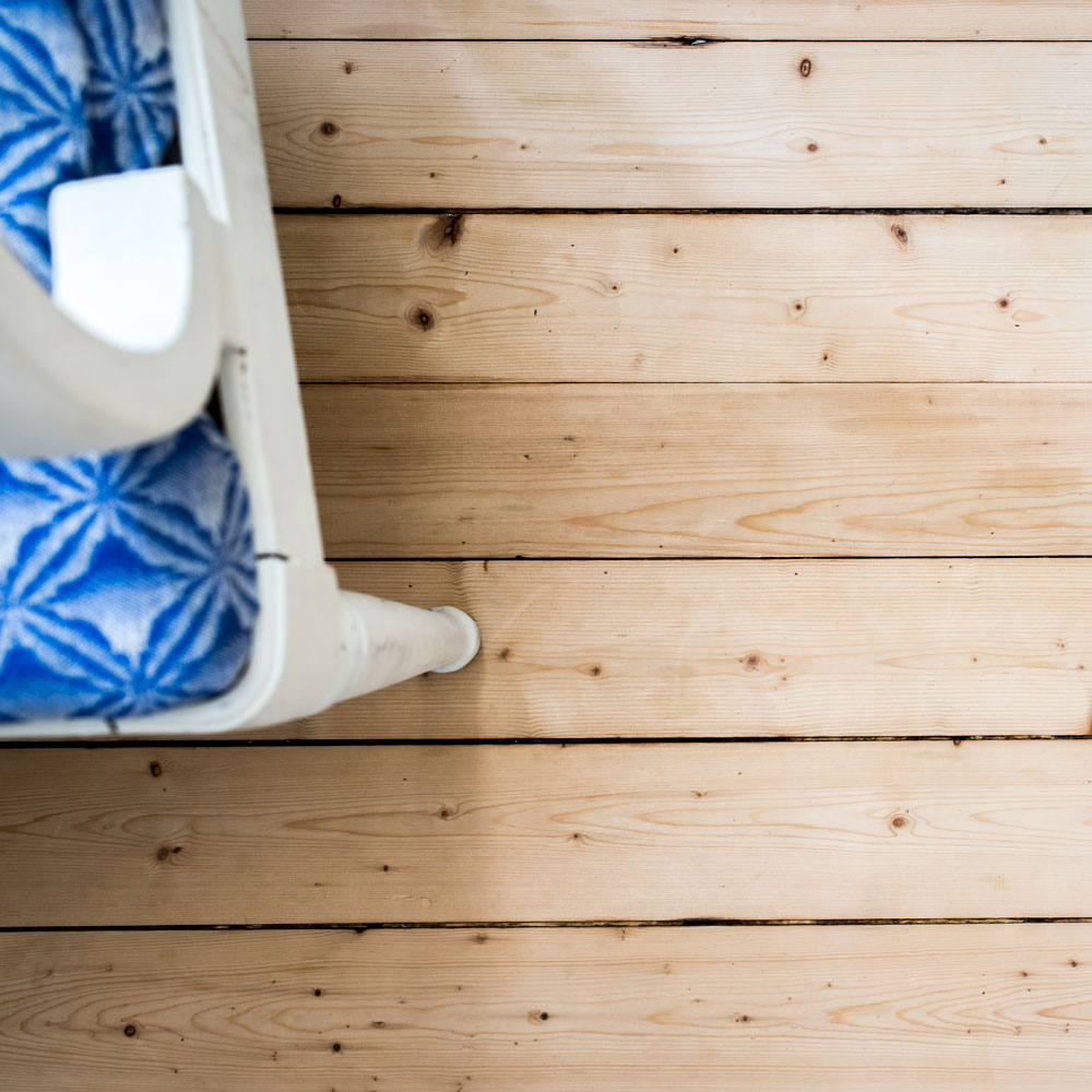 Et sæbeskuret køkkengulv af gran.