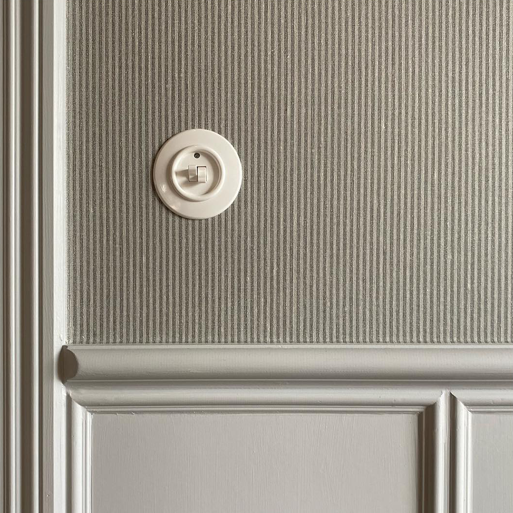 afbryder med dobbelt vippe på tapetseret væg