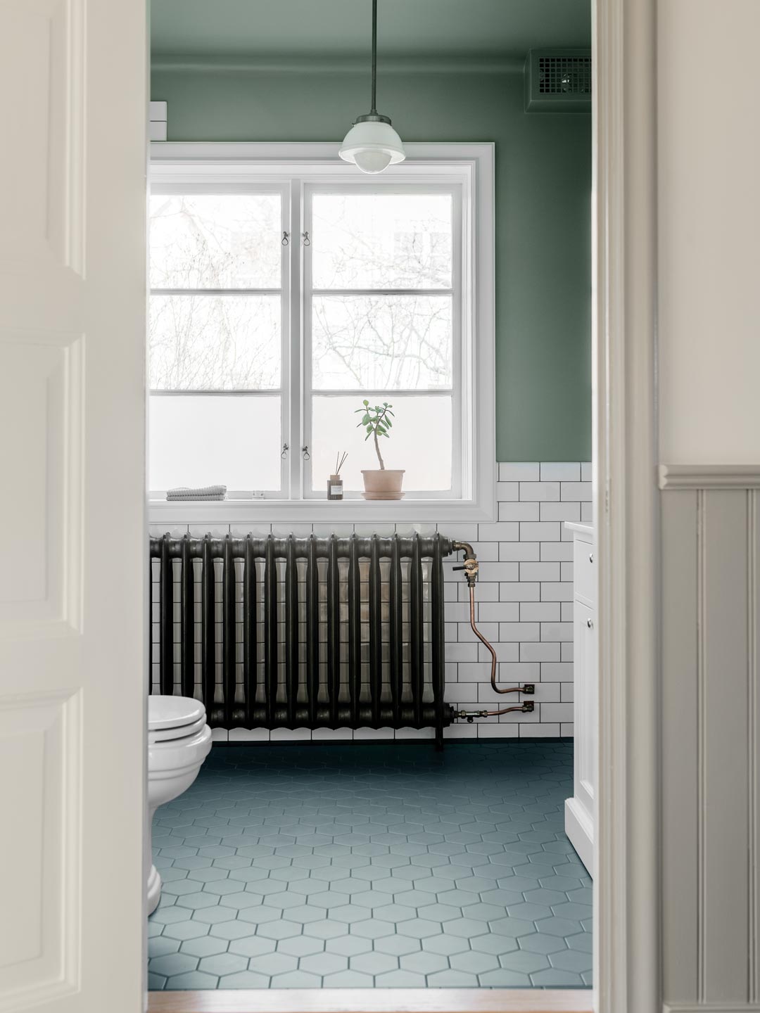 Badev&aelig;relse med gr&oslash;nne v&aelig;gge, hvide fliser og gr&oslash;nt sekskantede gulvklinker