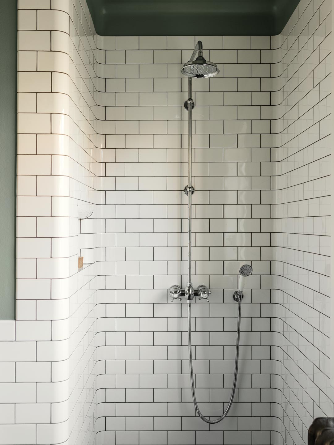 Bruseplads med hvide fliser, gr&oslash;nmalet loft og klassisk krombruser