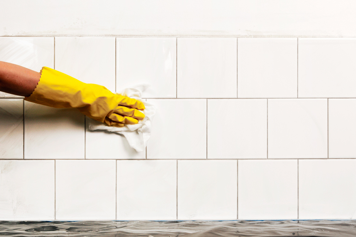 Endelig aft&oslash;rring af fliser med klud for rent resultat.