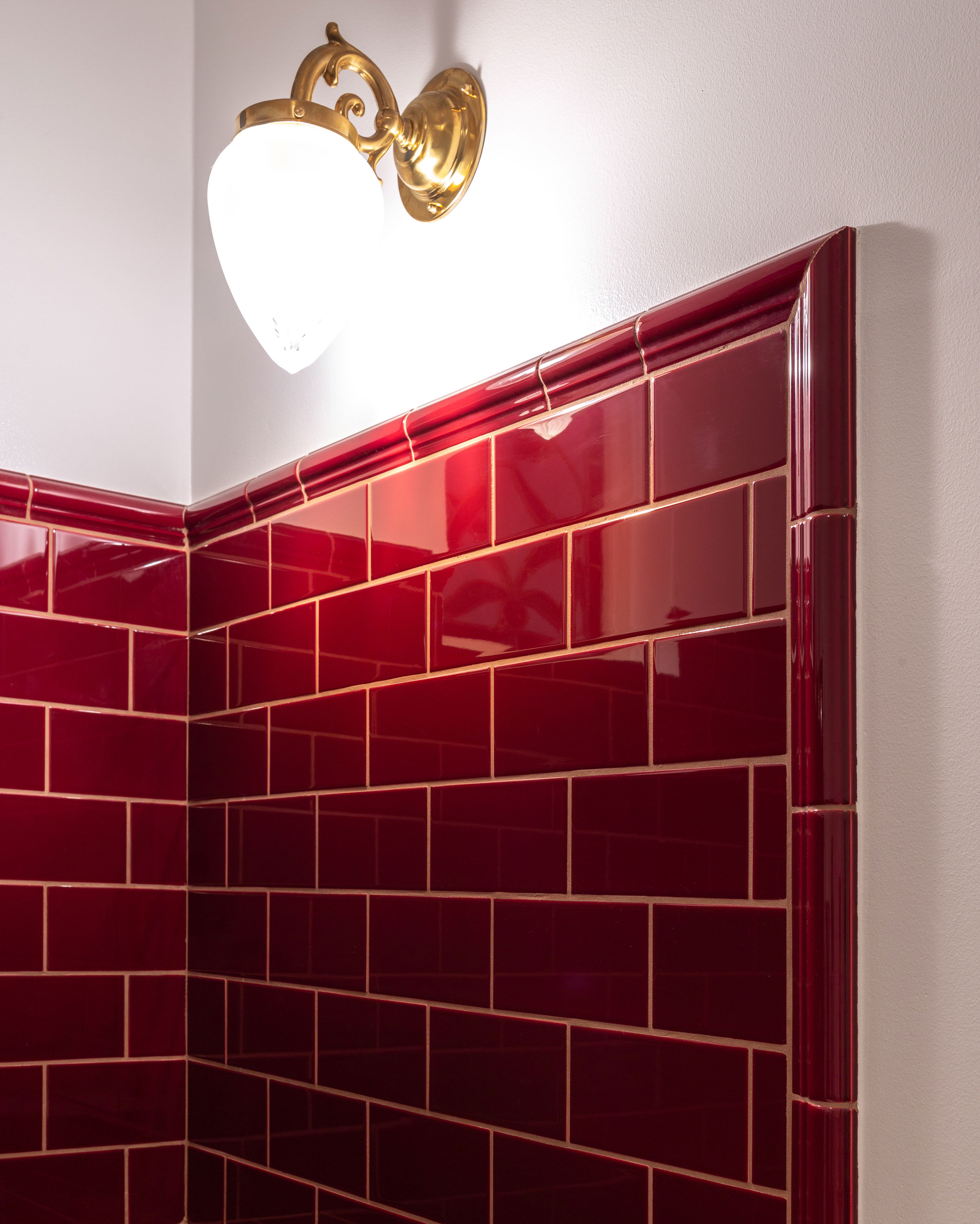 Flisebelagt hj&oslash;rne i vinr&oslash;d med dekorativ profileret kant