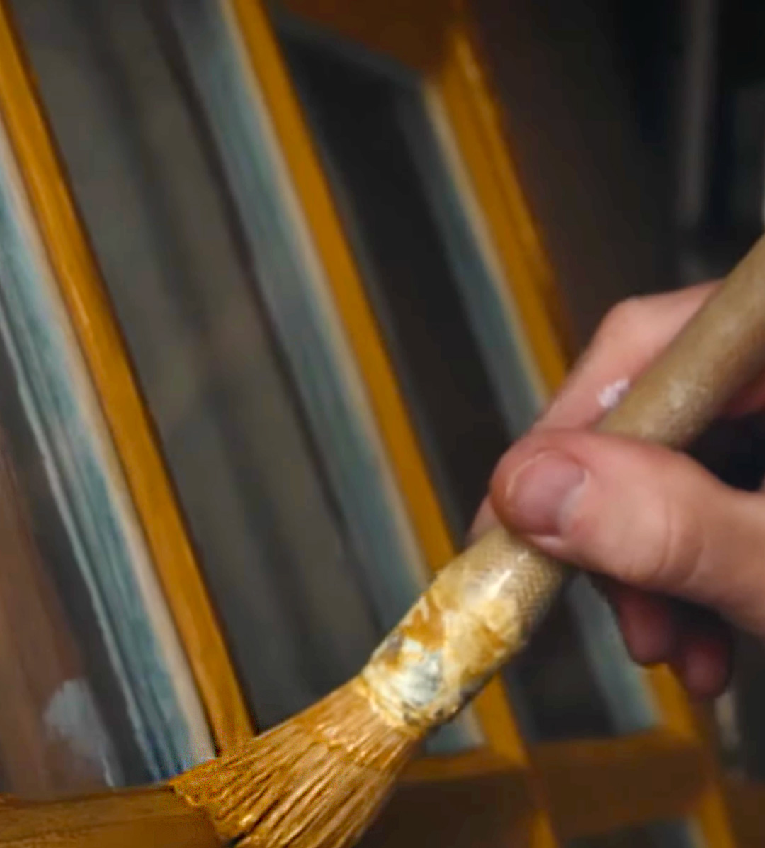 En grundmalet vinduesram males med linoliemaling i gul.