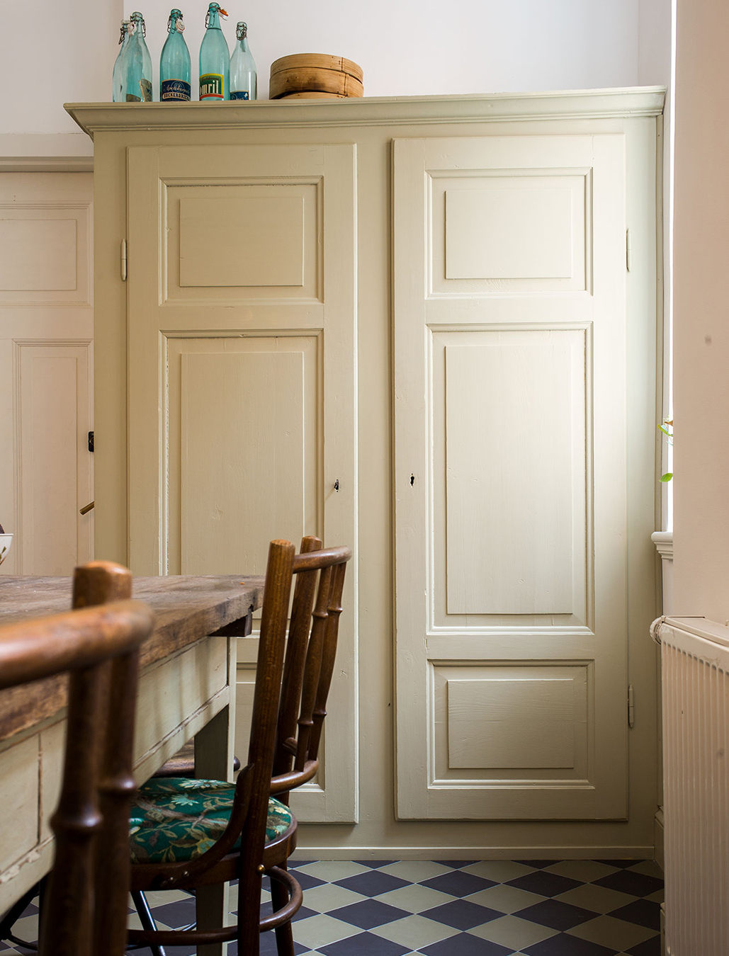 K&ouml;kssk&aring;p m&aring;lat med linoljef&auml;rg. Klinkergolv lagt i rutor i svart pch gr&ouml;nt. K&ouml;ksbord i tr&auml;.