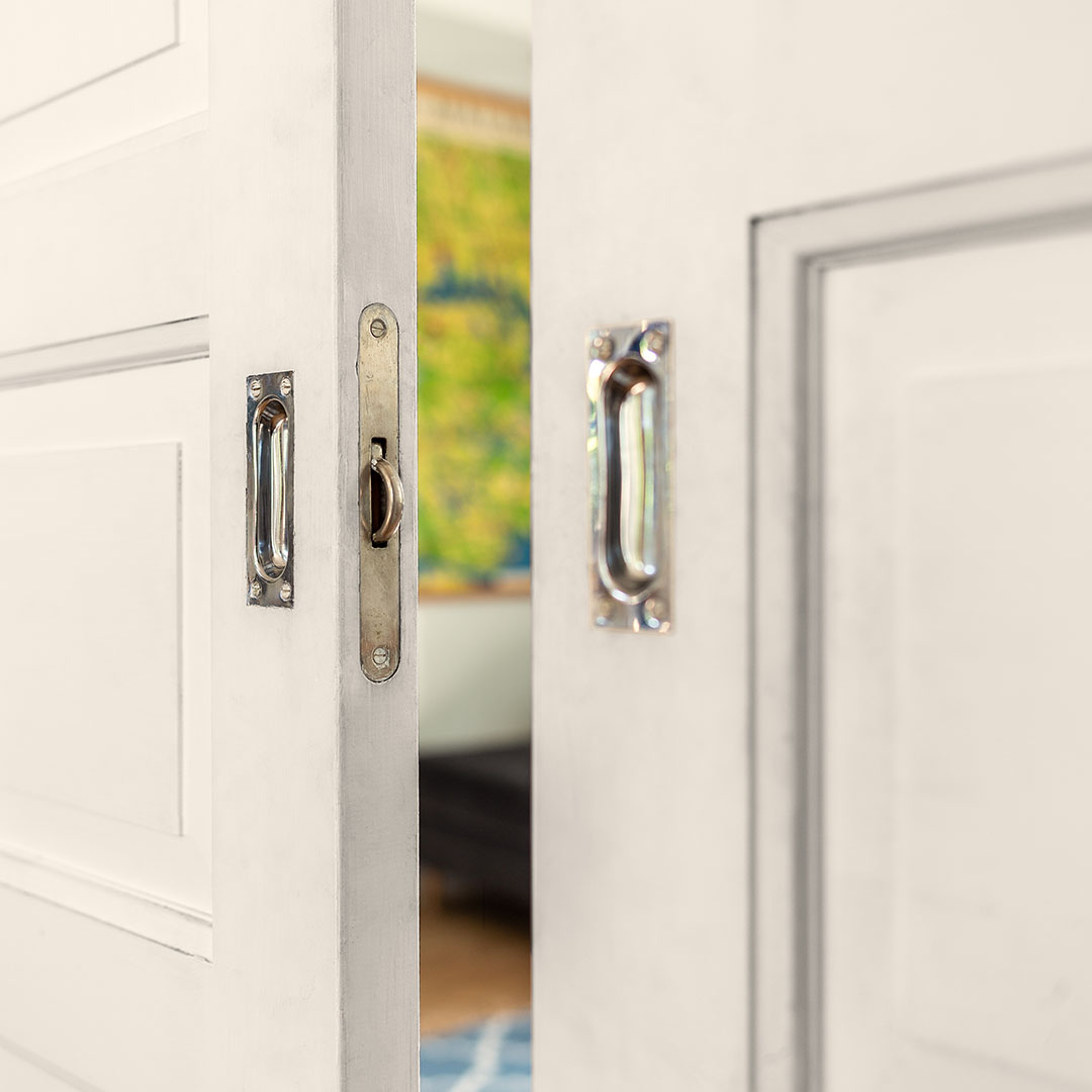 Halv&ouml;ppen skjutd&ouml;rr med skjutd&ouml;rrshandtag och kanthandtag i f&ouml;rnicklad m&auml;ssing.