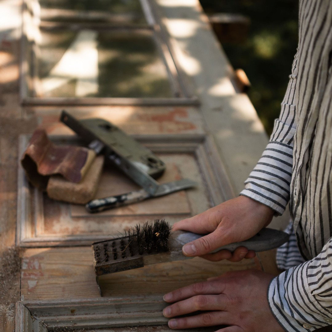 Skrapning av gammal f&auml;rg innan m&aring;lning.