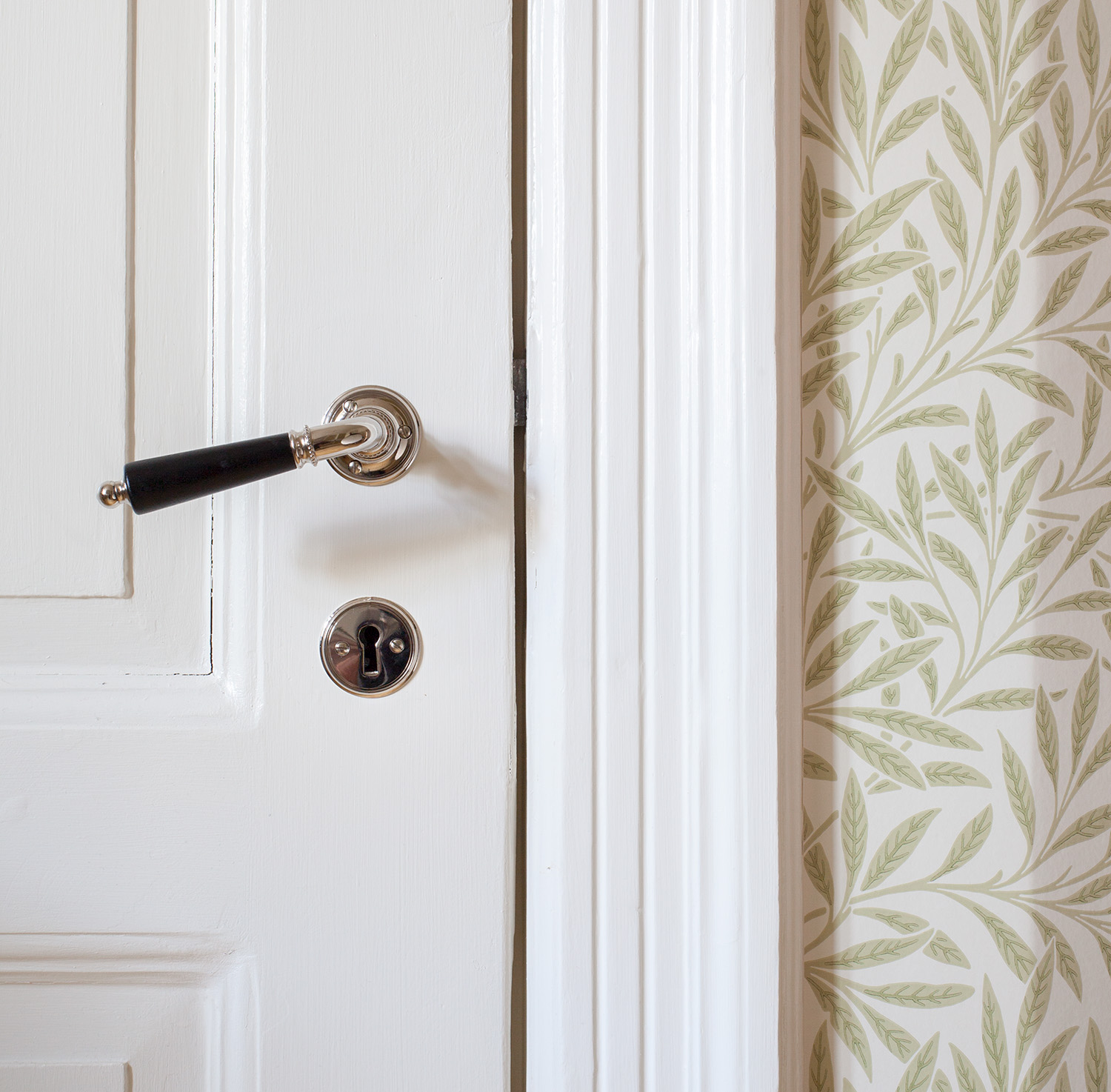 Monteret d&oslash;rh&aring;ndtag i klassisk stil p&aring; hvid indvendig d&oslash;r med n&oslash;gleskilt.