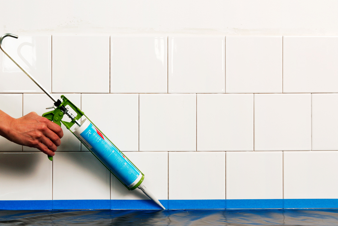 P&aring;f&oslash;ring af silikone mellem fliser med fugepistol.