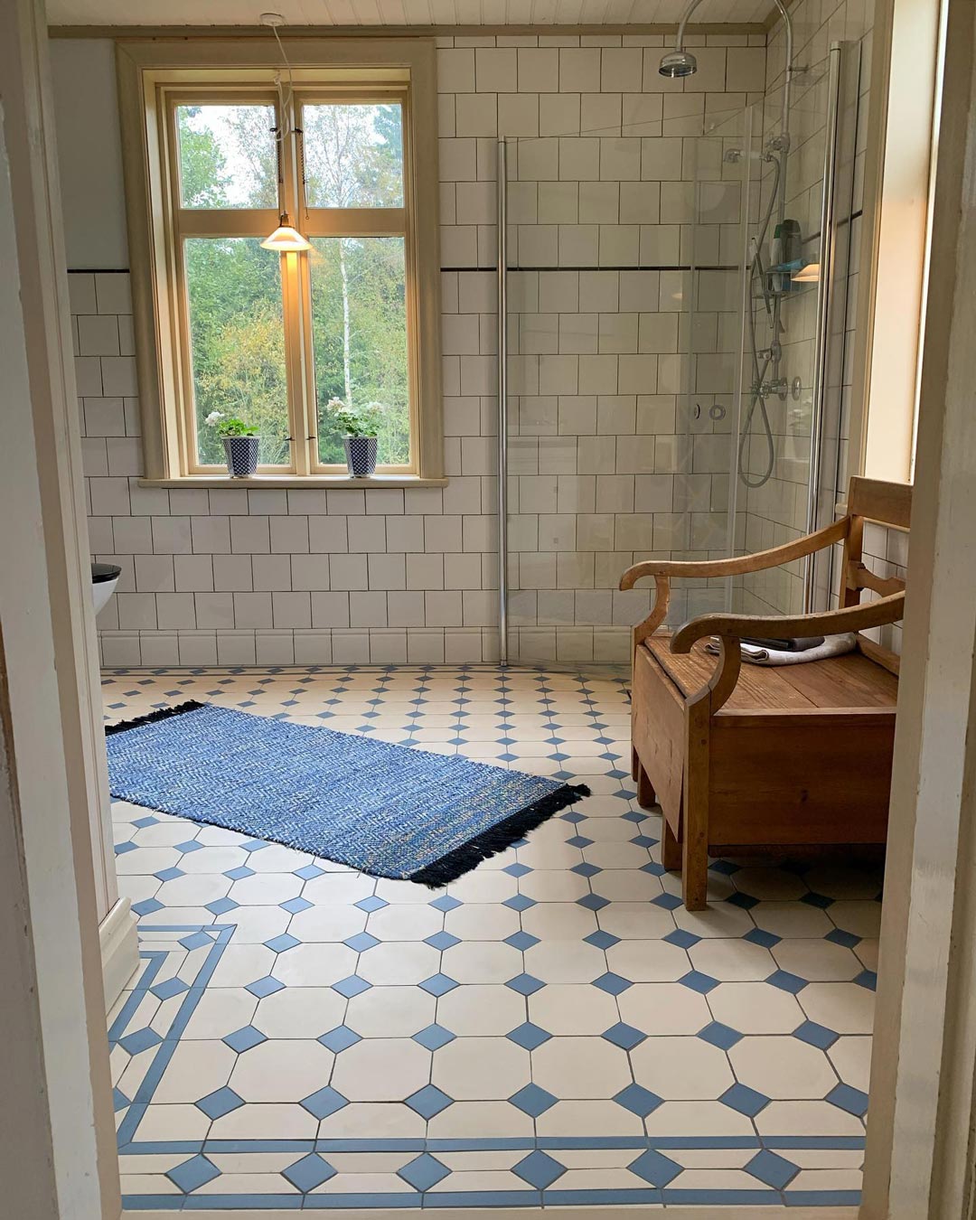 Badev&aelig;relse med hvide v&aelig;gfliser og Victorian gulvfliser York i bl&aring; og hvid med m&oslash;nsterbort